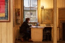 A man sits at his desk at an art gallery in Soho